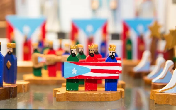 Three Kings of Puerto Rico holding the Puerto Rican flag.