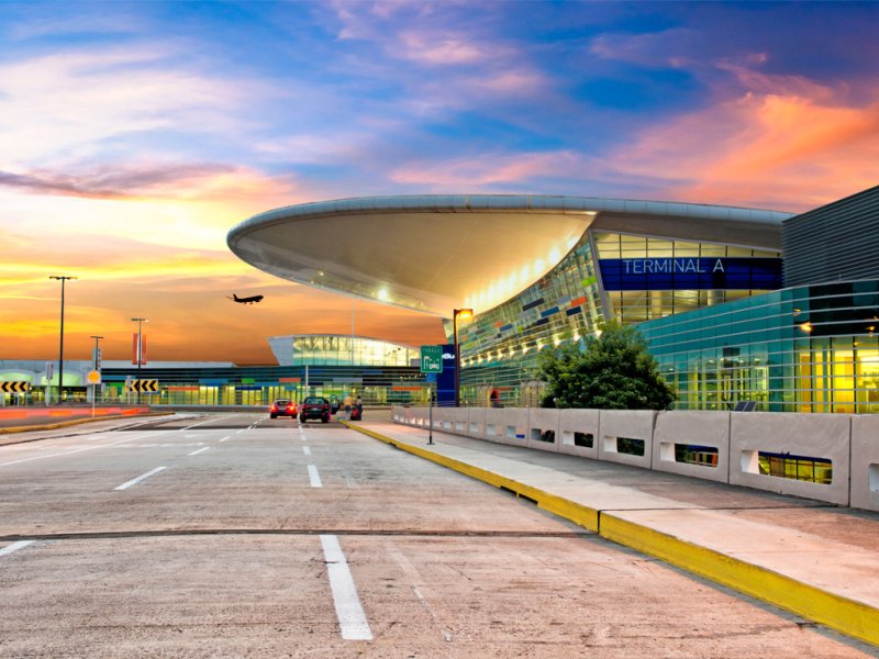 A colorful sky is visible behind the modern designed terminal building of the Luis Munoz International Airport near San Juan