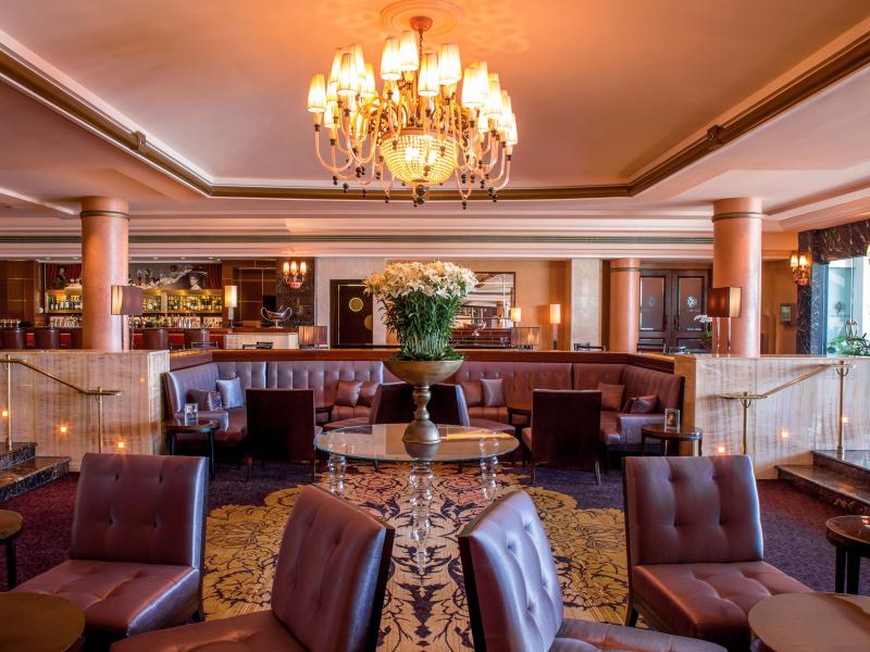 The elegant lounge at the Condado Vanderbilt hotel includes leather upholstery, marble columns and an ornate chandelier.