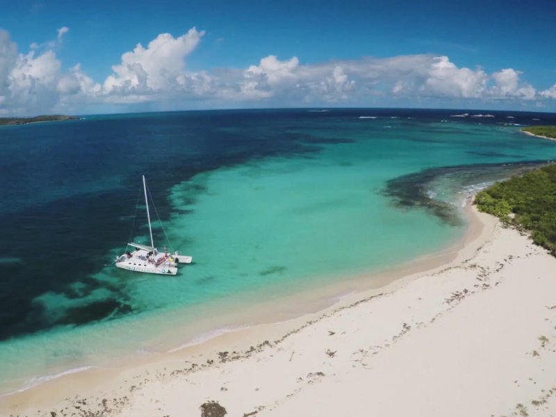 a sailboat idles near Icacos islet. 