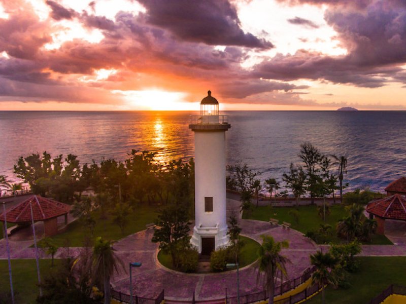 The sun sets behind a lighthouse in Rincón. 