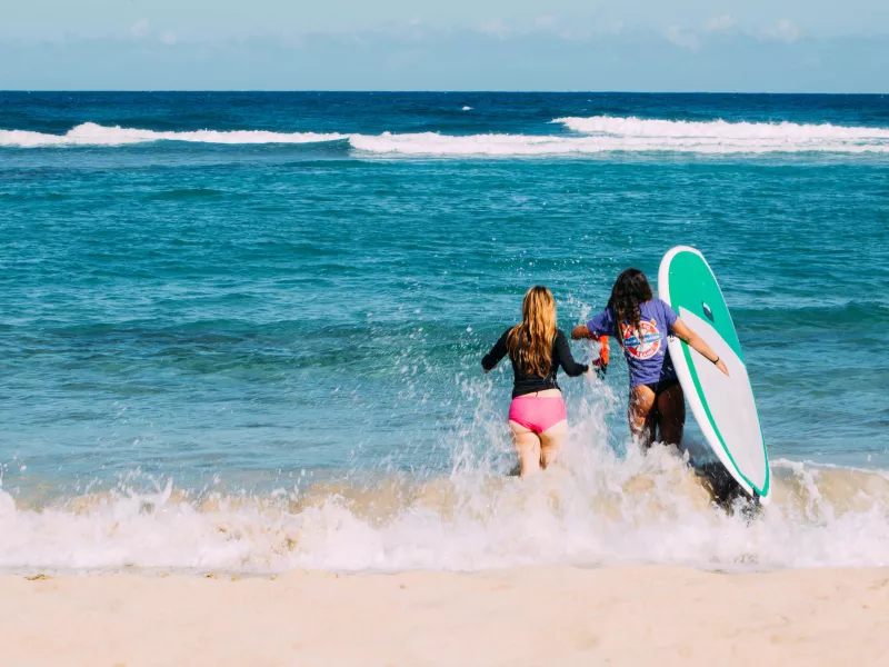 Two women run through the waves at Jobos Beach in Isabela. 