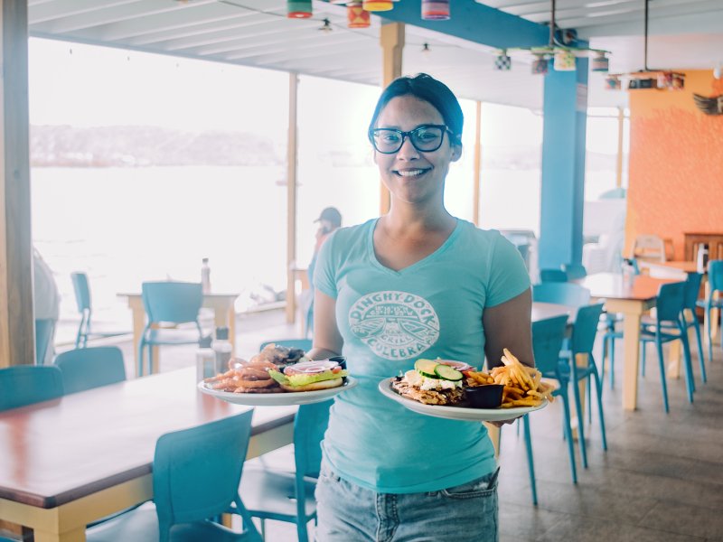 A waiter holds two plates with delicious food in Culebra.