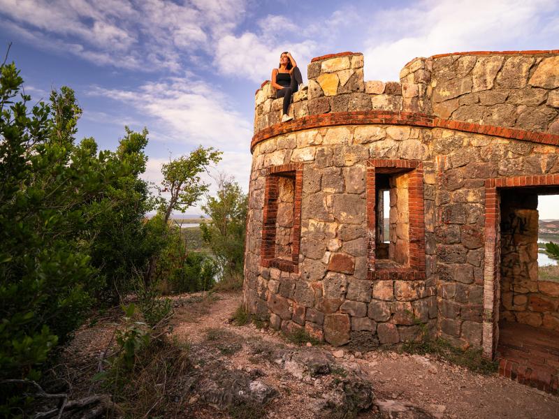 A woman sits on top of a historic fort in the Guánica Dry Forest.