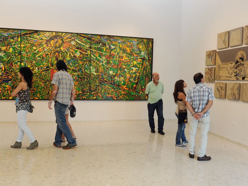 La gente ve una exhibición de arte en el Museo de Arte de Bayamón.