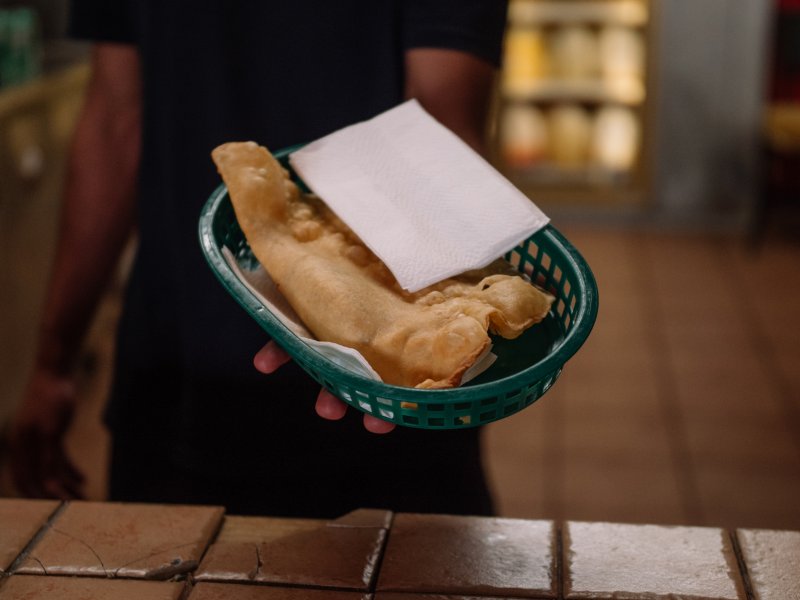 A server at Pastelillos Lamboy in Manati holds out a basket of pastelillos.