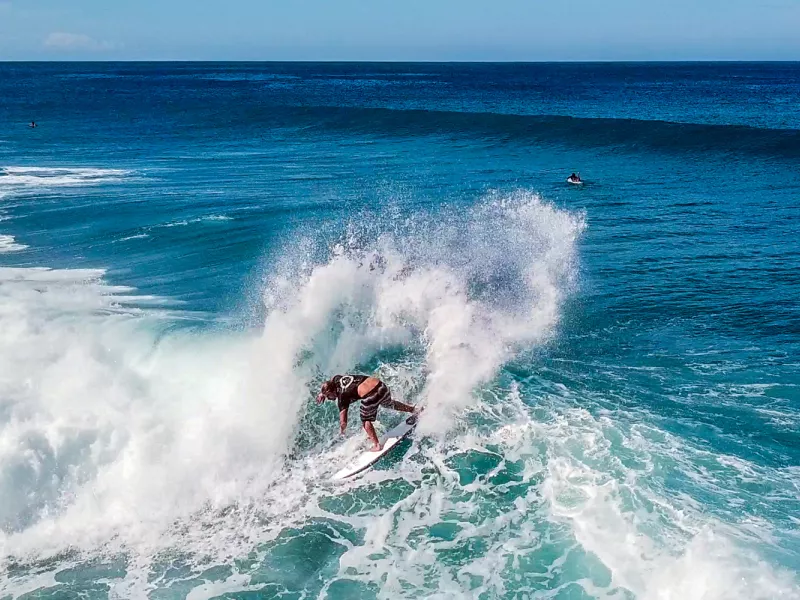A surfer carves through a beautiful wave in Rincón, the heart of Puerto Rico surfing.