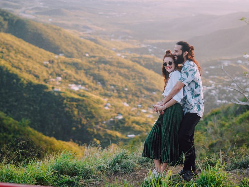 Una pareja se abraza sobre un hermoso valle de montañas.
