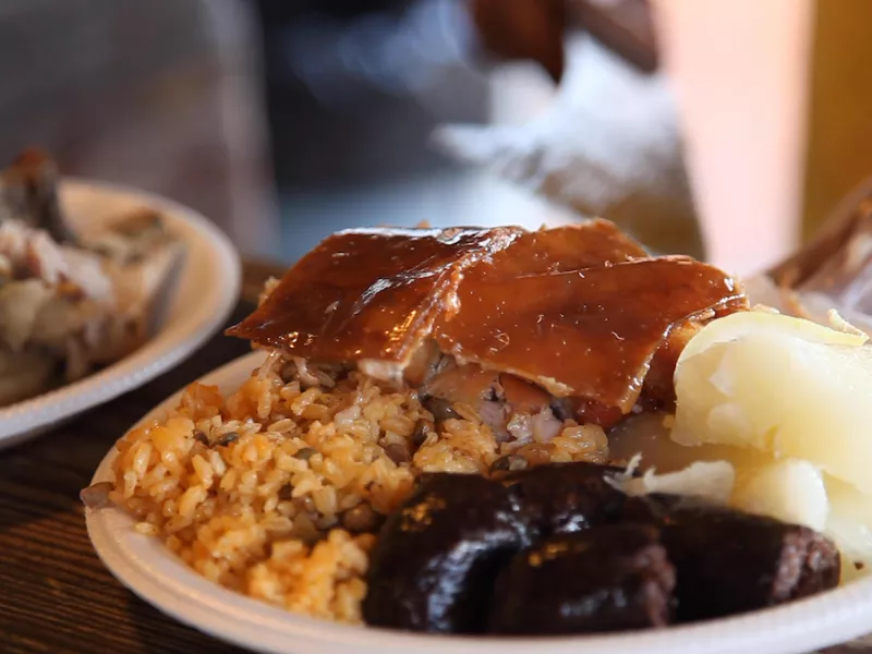 Plate of lechón, arroz con gandules, and morcilla at a lechonera in Puerto Rico