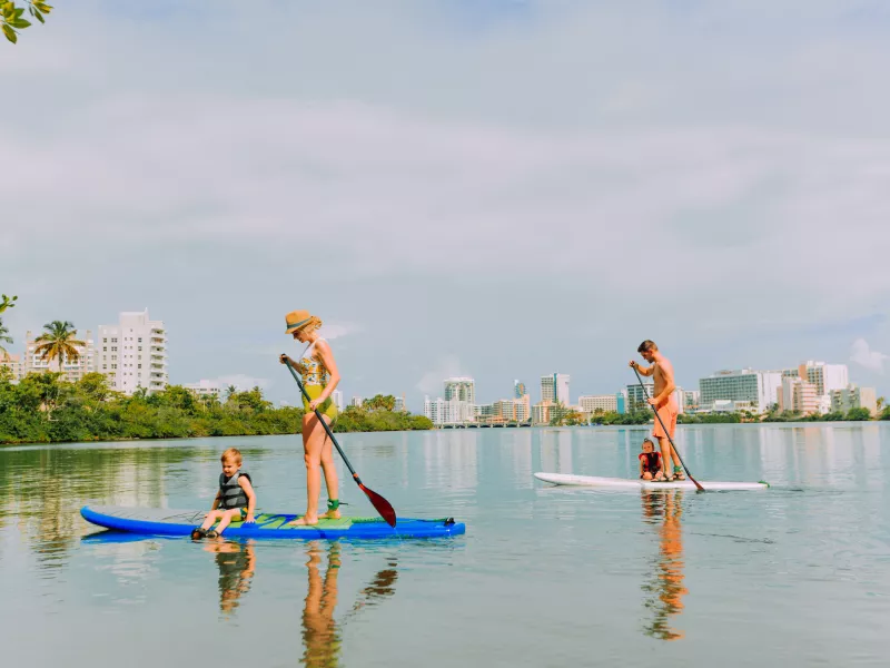 A family paddle boards at the Condado lagoon.