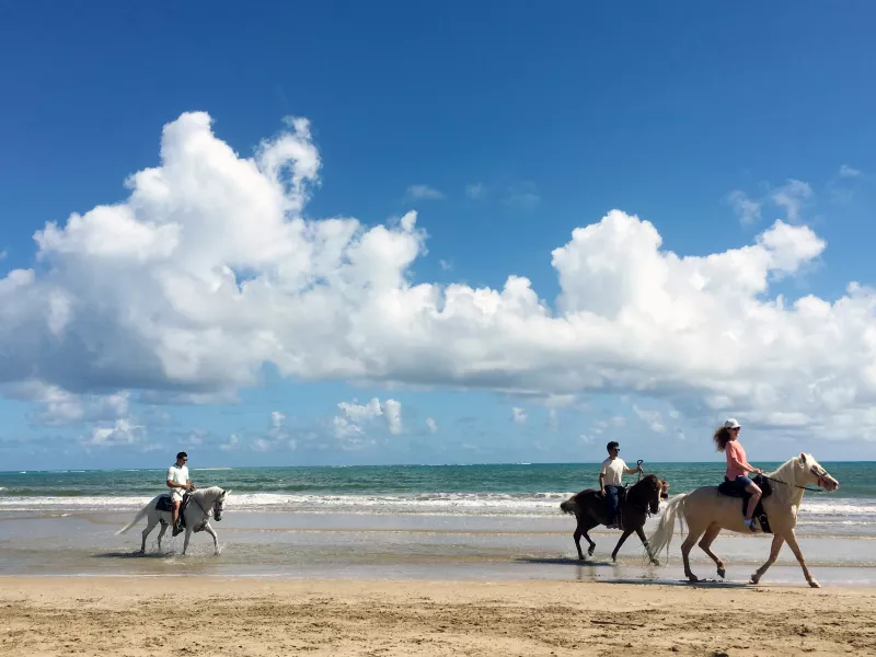 Horseback riding in the beach.