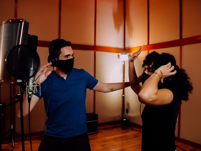 A couple enjoying reggaeton music in a studio.