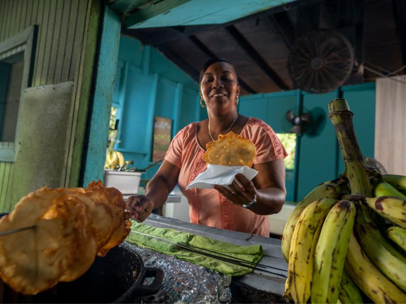 A woman serves a freshly fried fritter at kiosk in Pinones, Puerto Rico