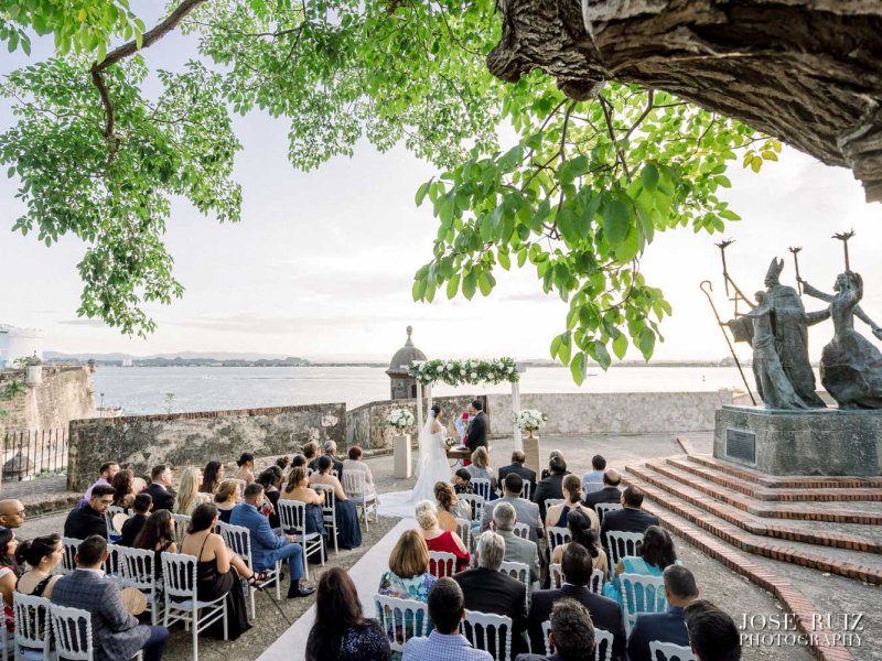 Guests seated for a wedding in front of the iconic La Rogativa statue in Old San Juan.