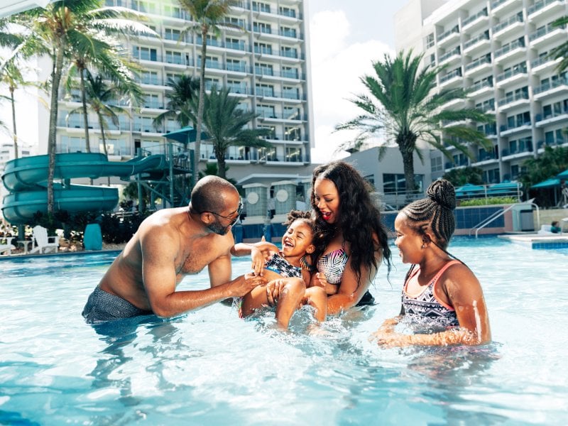 Una familia juega junta en una piscina.