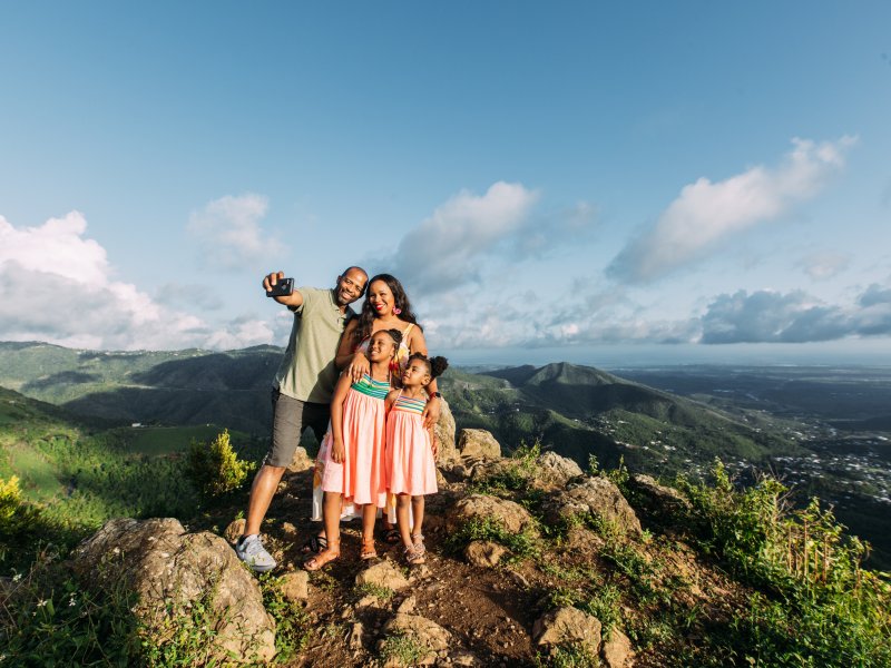 A family poses for a selfie during a hike. 