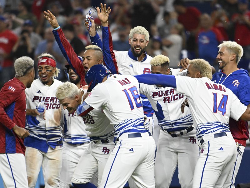 Grupo de jugadores de béisbol con cabello rubio teñido celebrando.