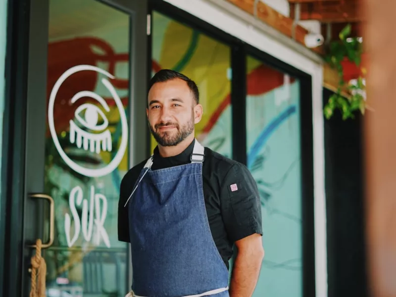Chef Rafael Ubior posesin front of his restaurant SUR Barra Nikkei