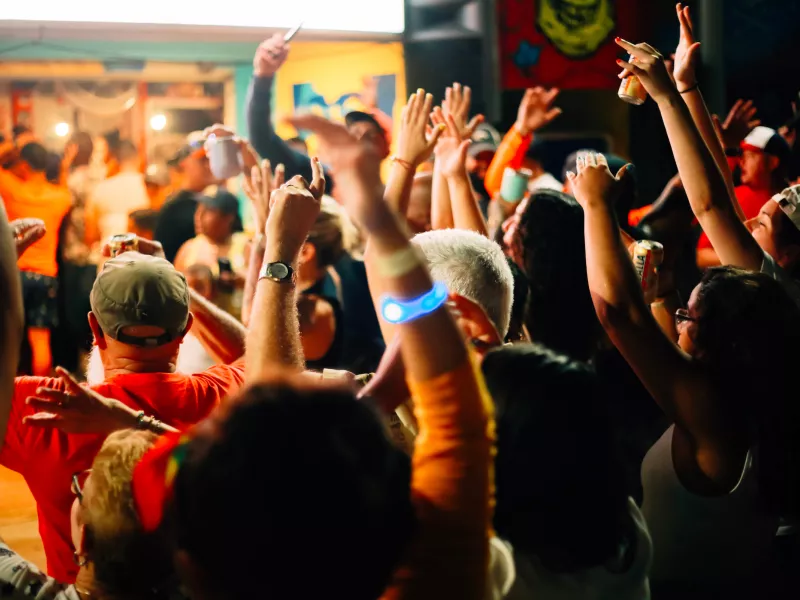 Crowd gathered at night in La Placita de Santurce, with people raising their hands and enjoying live music, nightlife, and the lively atmosphere of one of San Juan's most popular social destinations.