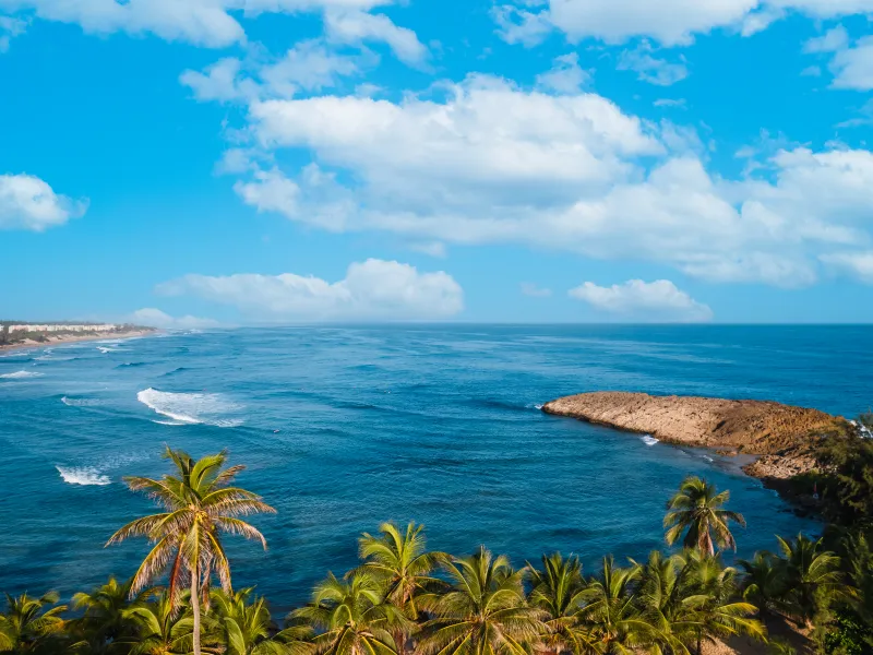 Dos mujeres corren entre las olas en Playa Jobos en Isabela.