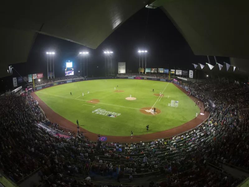 Night view of Hiram Bithorn Stadium in San Juan filled with fans during a baseball game.