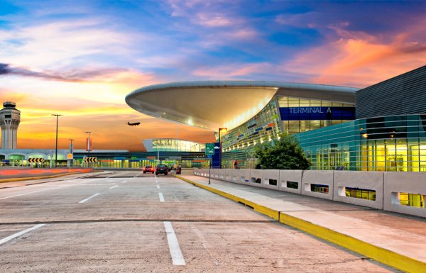 A colorful sky is visible behind the modern designed terminal building of the Luis Munoz International Airport near San Juan