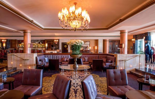 The elegant lounge at the Condado Vanderbilt hotel includes leather upholstery, marble columns and an ornate chandelier.