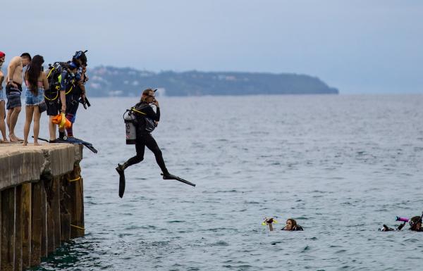 Dive instructor jumps into ocean at Crash Boat Beach.