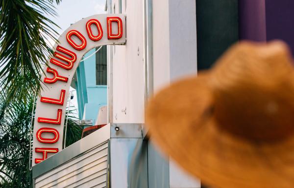 Woman in a hat standing outside the historic Hollywood Theater in Coamo.