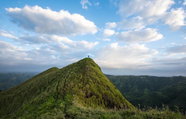A person stands at the peak of mountain in the central region of puerto rico.