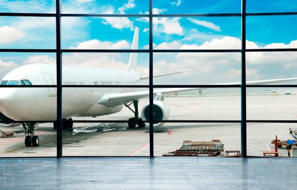 An airplane on runway viewed through the windows from the inside of the airport in San Juan.