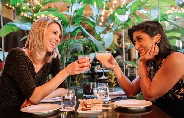 A couple enjoys craft cocktails while dining