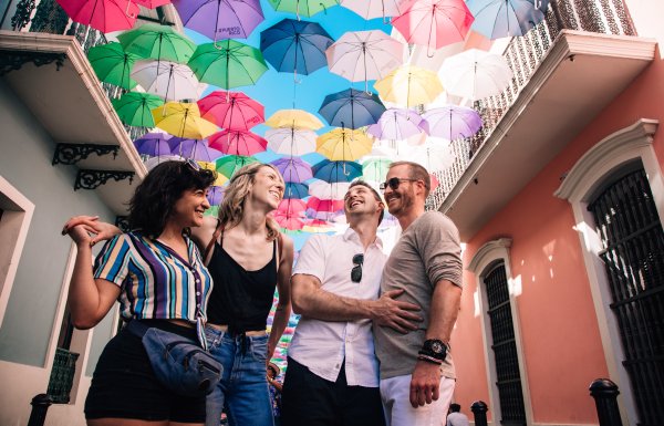 Two couples laugh on the street in old san juan.