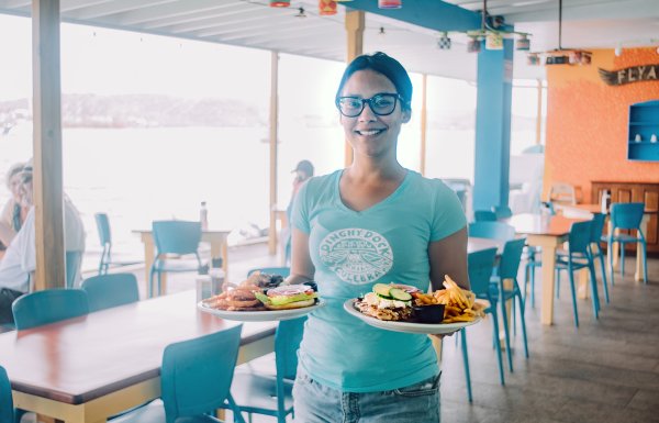 A waiter holds two plates with delicious food in Culebra.