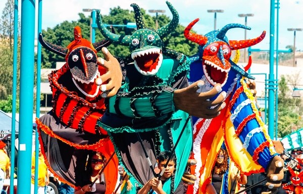 A group of large, colorful puppets in a carnaval parade in Ponce.