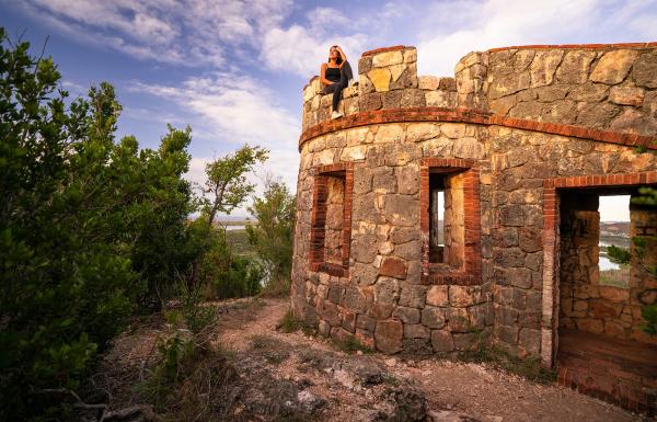 A woman sits on top of a historic fort in the Guánica Dry Forest.