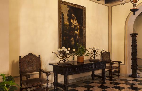 A historic painting hangs on a wall inside el convento hotel