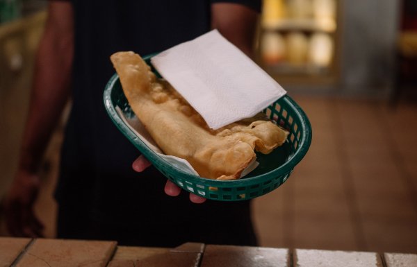A server at Pastelillos Lamboy in Manati holds out a basket of pastelillos.
