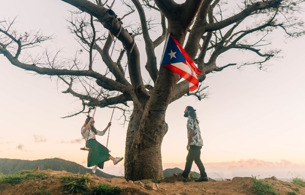 A couple enjoys the outdoors on top of a mountain.