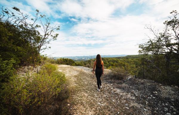 A woman is hiking the Ballena and LLuberas trails in Guánica