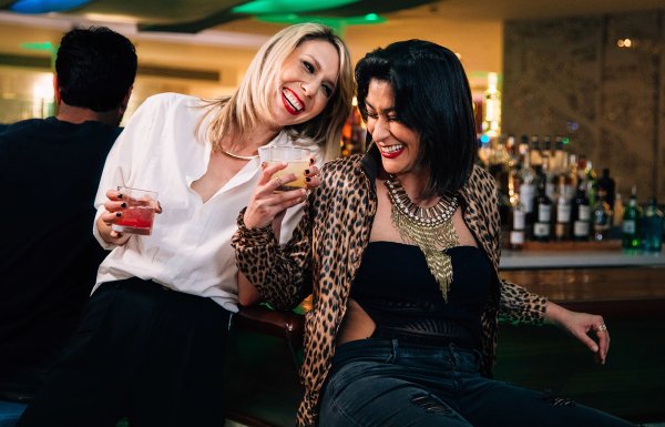 A couple of lesbians enjoying their cocktails at a bar.