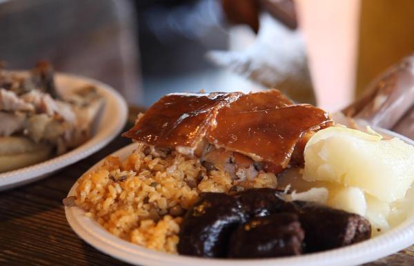Roasted pork, rice and pigeons peas and morcilla on a dish.