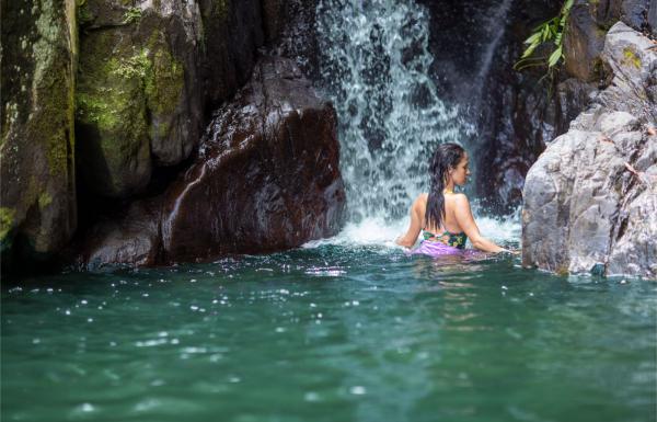 A woman swims in Juan Diego Falls waterfall in Puerto Rico