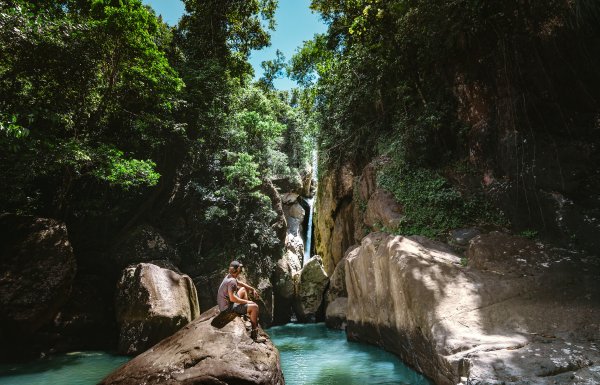 Hombre frente a la cascada.