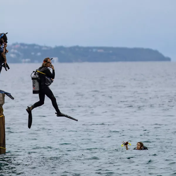 Dive instructor jumps into ocean at Crash Boat Beach.