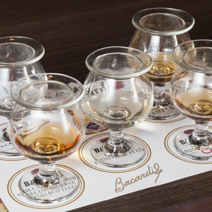 five tasting glasses with different types of rum lined up at casa bacardi