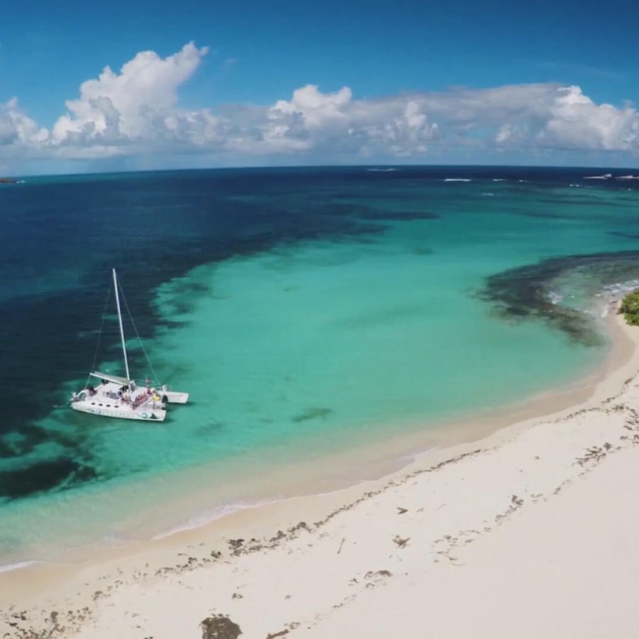 a sailboat idles near Icacos islet. 