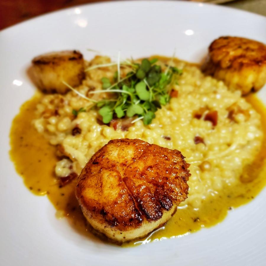 Un hermoso plato con vieiras a la plancha en el restaurante Santaella en San Juan