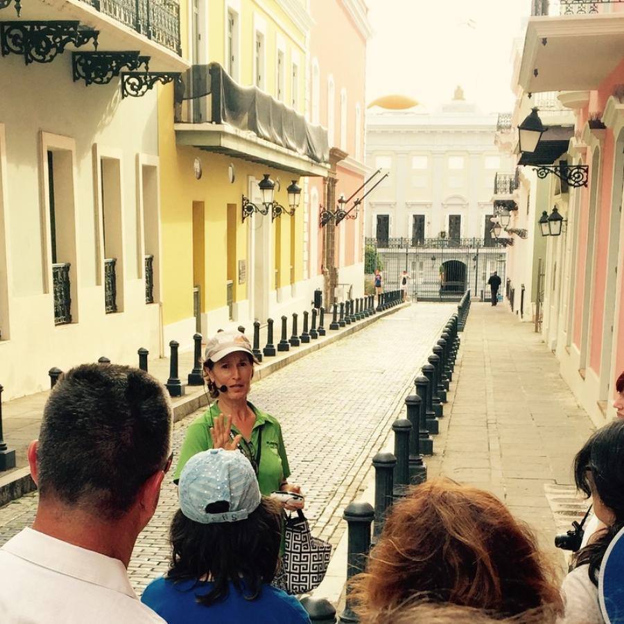 A female tour guide leads a group on a walking tour of Old San Juan.