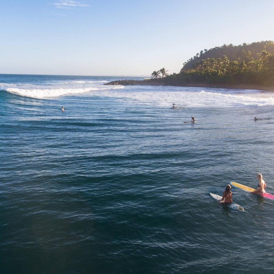 Two people waiting to catch a wave at Domes Beach in Rincon. 